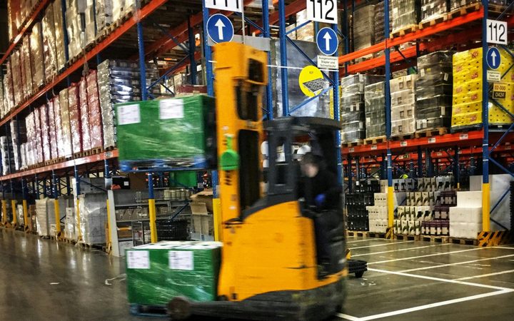Heftruck tussen de stellingen van een distributiemagazijn