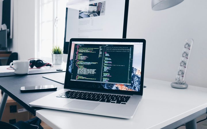 Laptop met programmeercode op een werkplek, software en IT