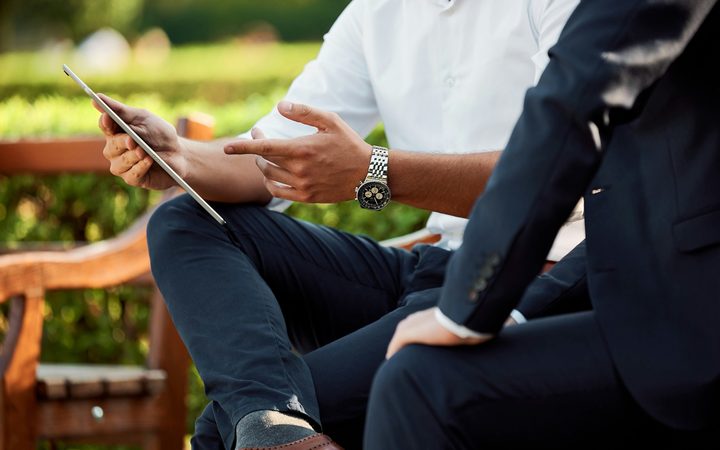 Twee zakelijke adviseurs in overleg met een tablet